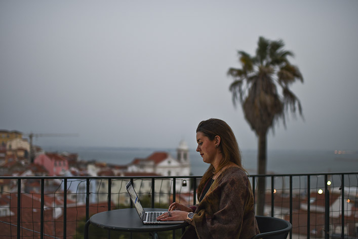 A woman works on her laptop on a patio. Finding a peaceful place to work can be good for strategic thinking.