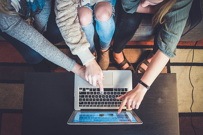 people pointing to a laptop screen