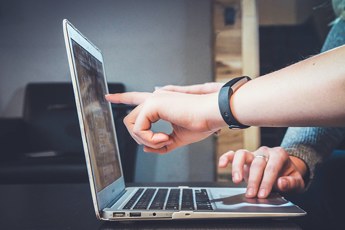 Person pointing to computer screen.