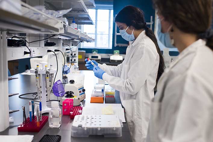 A woman reads a test tube label. Healthcare content marketing provides patients and clients with trustworthy information.