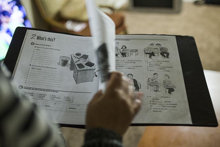 A student flips through a language-learning workbook. 