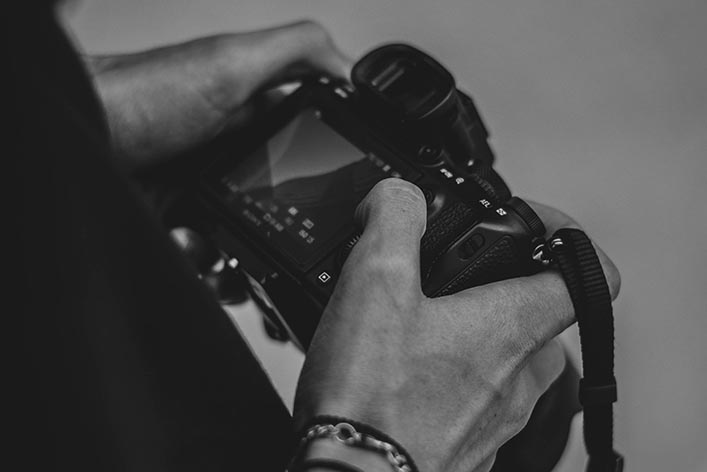 A photographer holds a camera. 