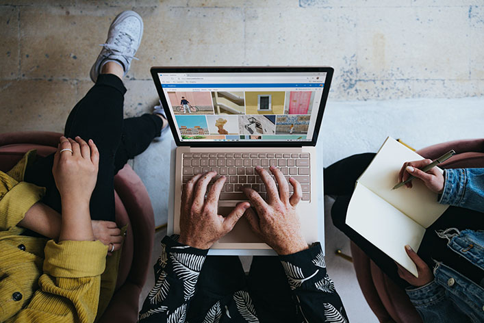 Three people huddled around a laptop.