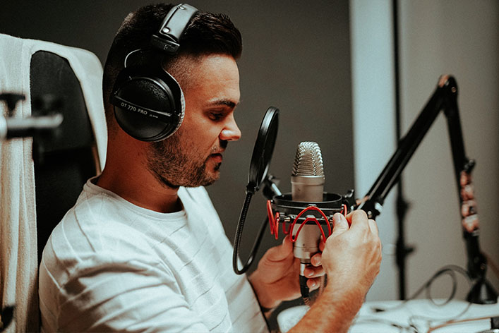 man sitting in front of podcast microphone