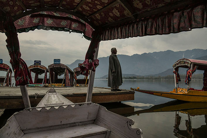 A man looks across a river. World Review is a licensed content package that examines the impacts of globalization.